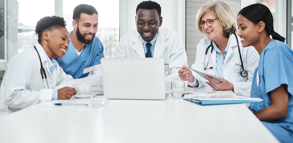 its all about exceptional healthcare shot group medical practitioners using laptop meeting hospital boardroom